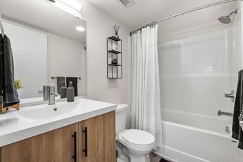 A white bathroom with a toilet, sink, and shower.
